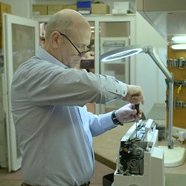 Man in blauw shirt is aan het werk in zijn workshop 