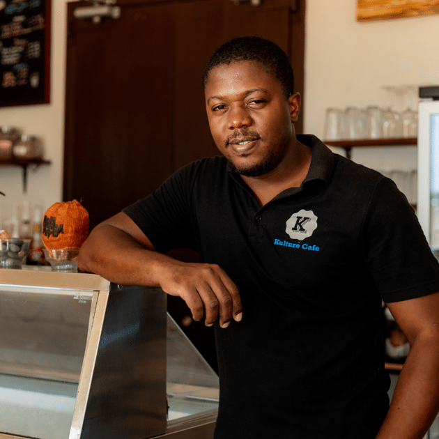 Man in zwart shirt leunt tegen bar aan