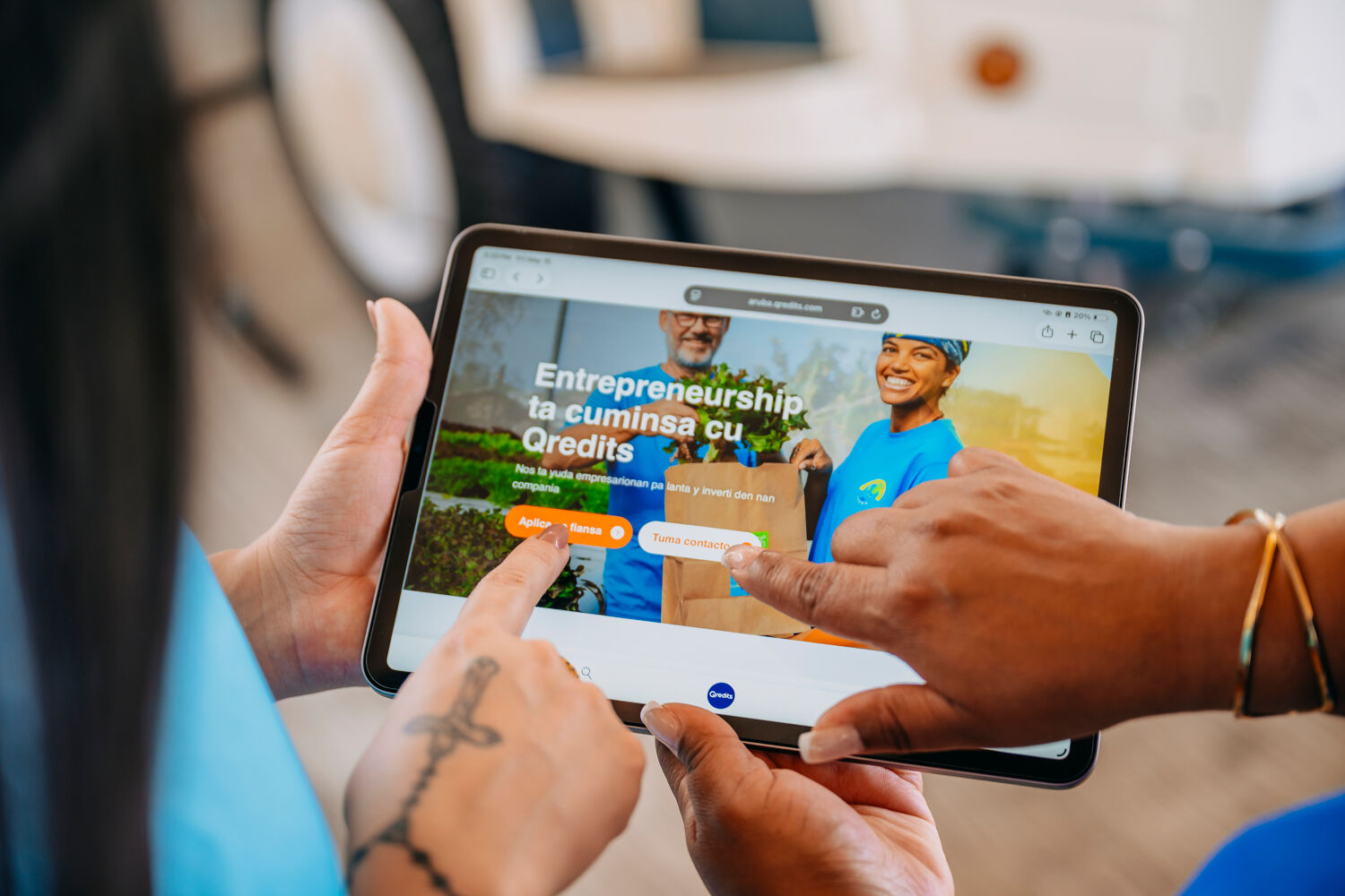 twee mensen klikken op tablet met de Qredits website
