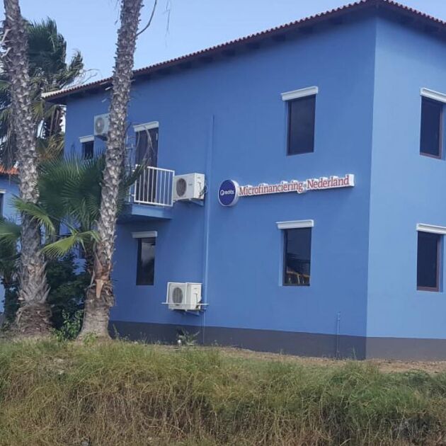 Blauw gebouw op Bonaire met bomen en gras