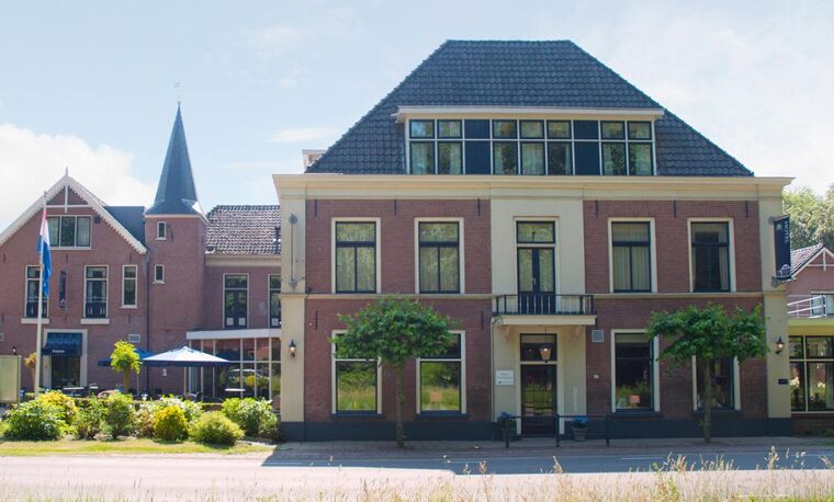 Hotelpand aan de straat met groen gras en balkon