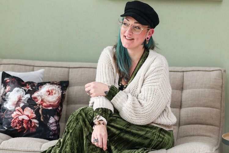 vrouw-met-pet-zit-op-bank-header