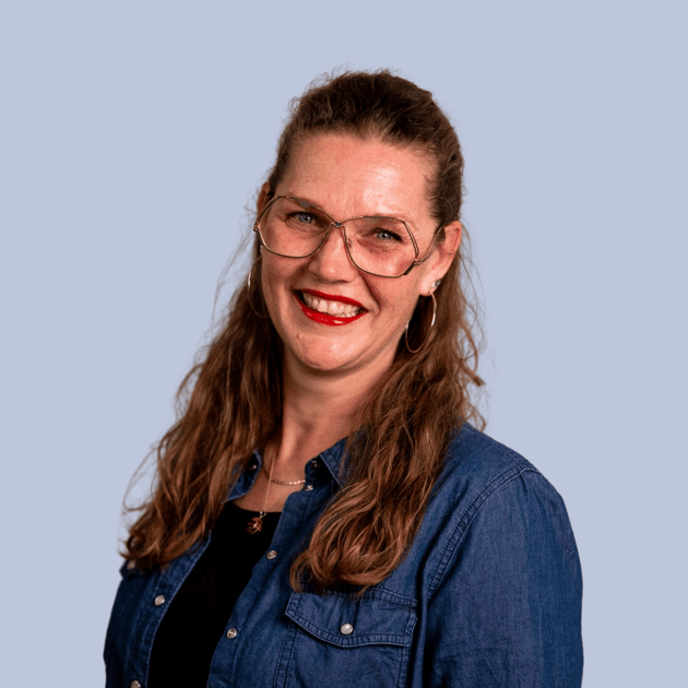 medewerker Qredits Lia Bakker vrouw in donker shirt voor grijze achtergrond