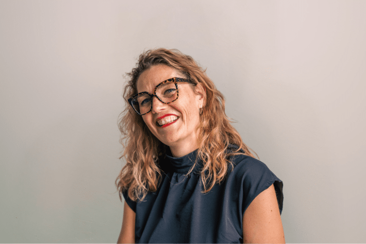 medewerker Qredits Lia Bakker vrouw in donker shirt voor grijze achtergrond