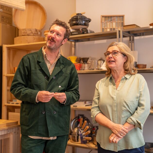 Man en vrouw staan in een winkel en zijn in gesprek, ze kijken weg. 