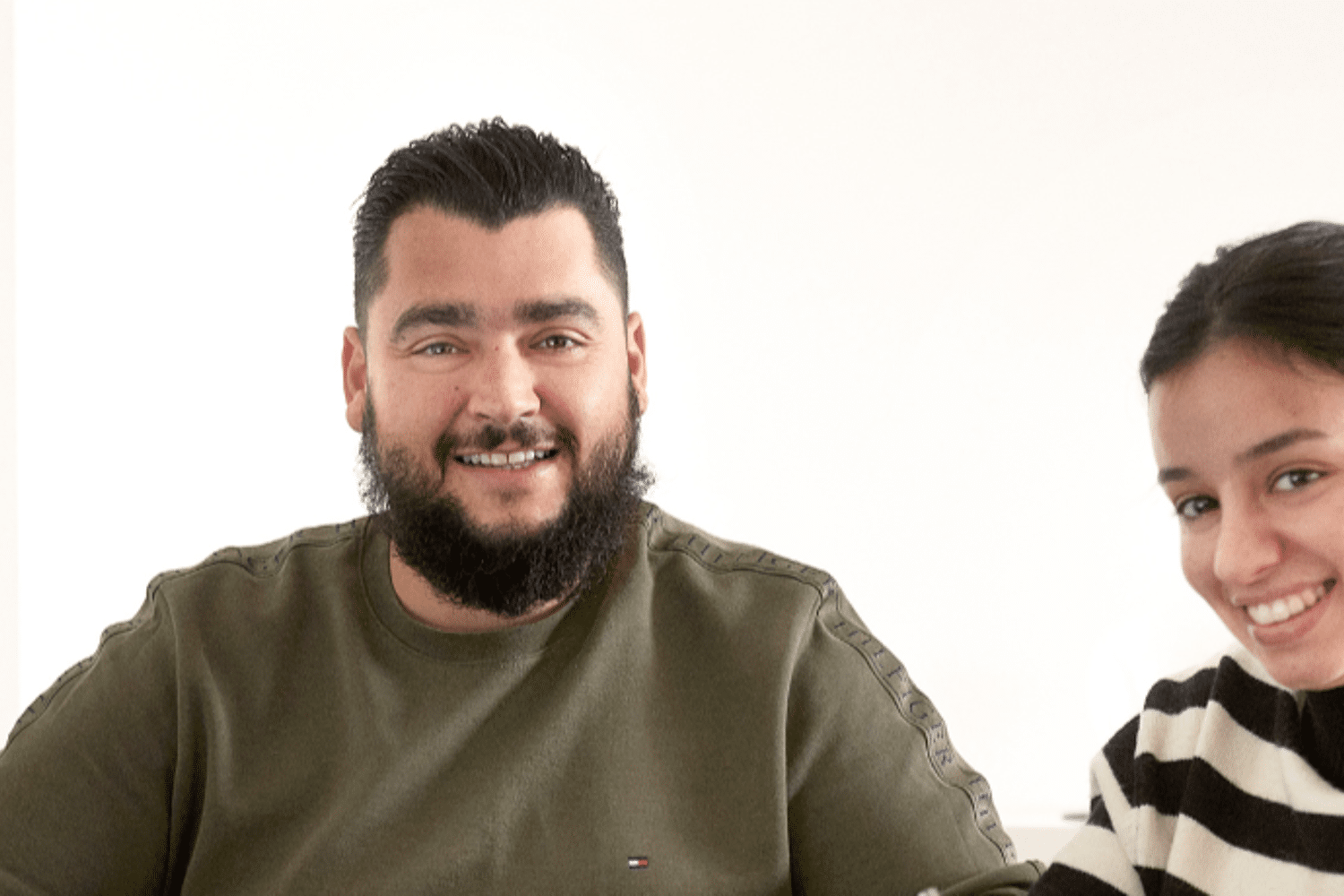 Man en vrouw kijken naar de camera en tekenen.