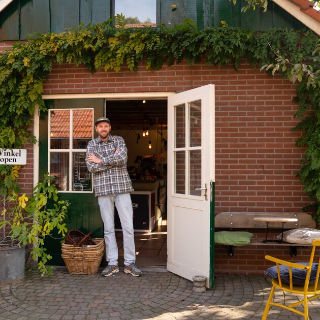 Man leunt trots tegen een deuropening aan. 