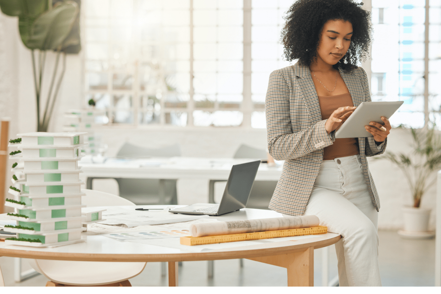 Vrouw zit op haar bureau en kijkt serieus naar haar ipad.