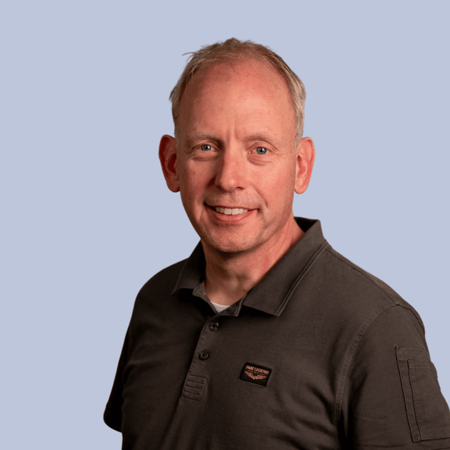 medewerker Qredits Peter Sanders man in blauw shirt voor grijze achtergrond