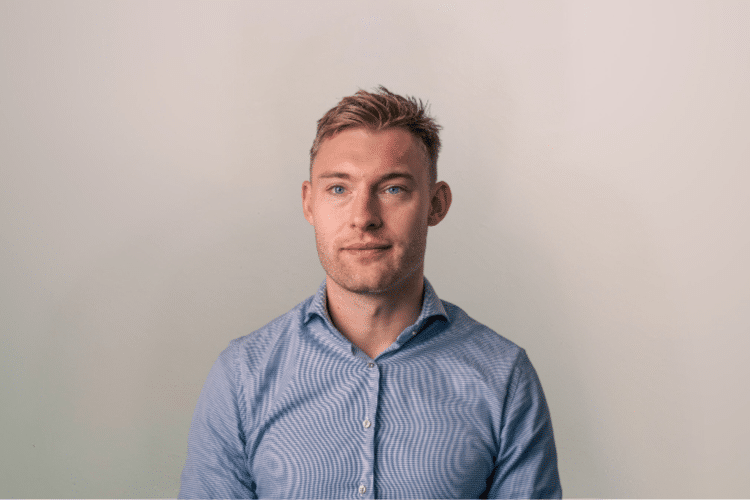 medewerker Qredits Rick Herman man in blauw shirt voor grijze achtergrond