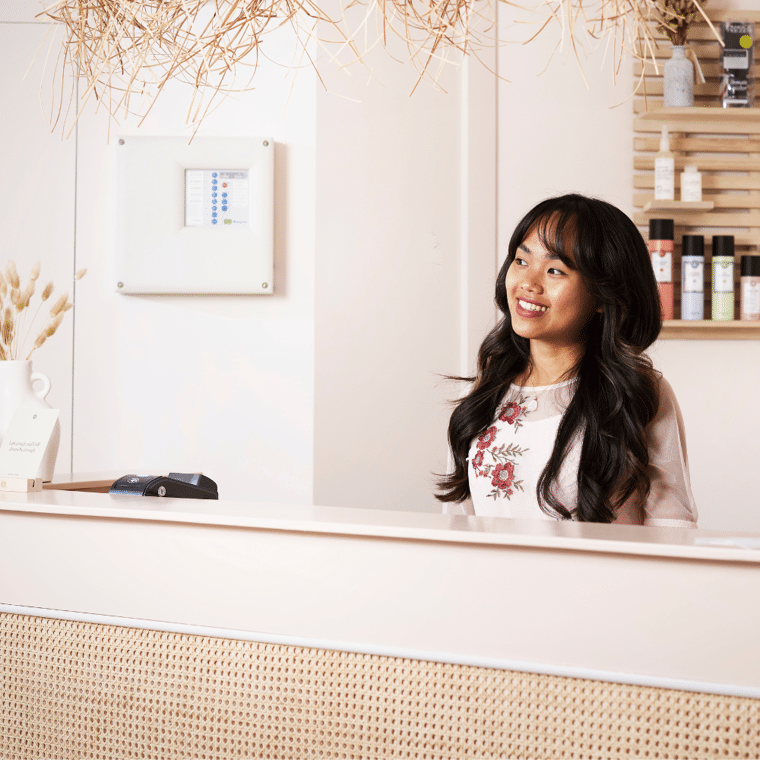 Vrouw zit achter balie na goednieuwsgesprek over kredietaanvraag