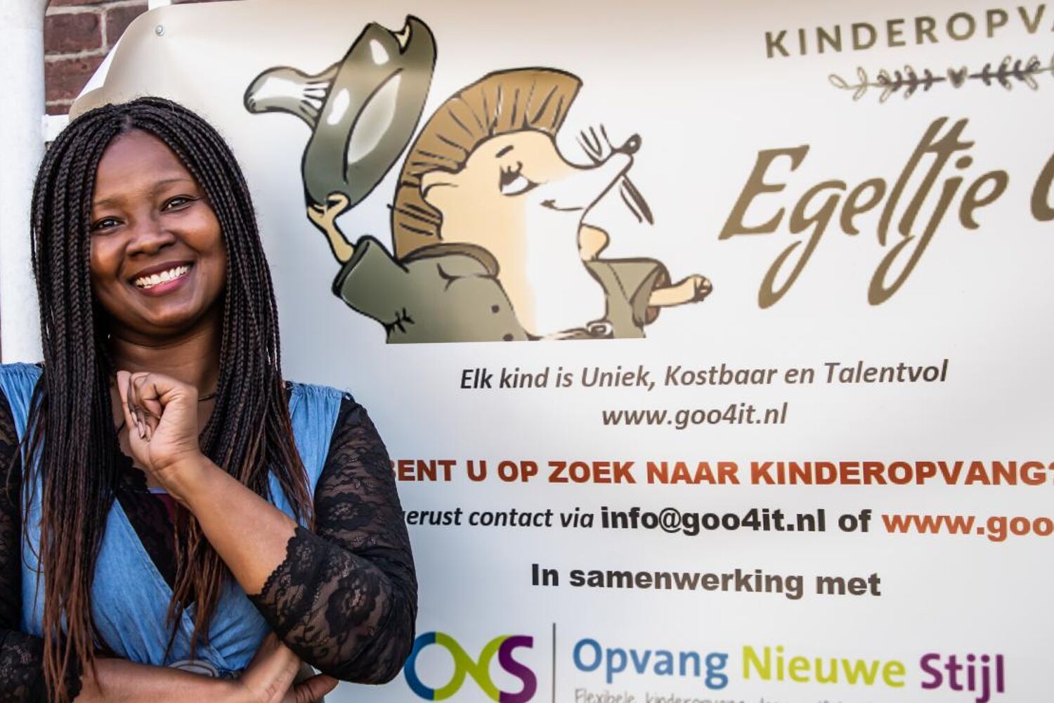 De eigenaresse van kinderopvang Egeltje Goo staat voor een bord van haar onderneming