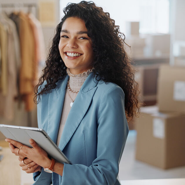 Vrouw met Ipad in de hand lacht in camera