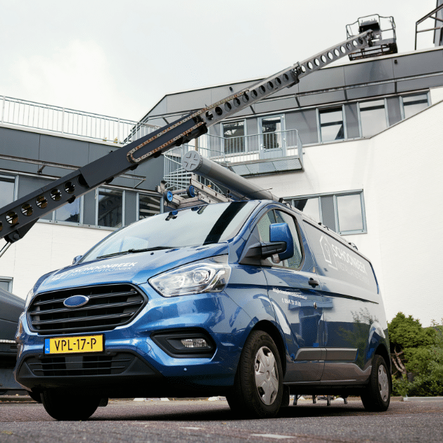 Blauwe werk auto staat buiten bij wit gebouw