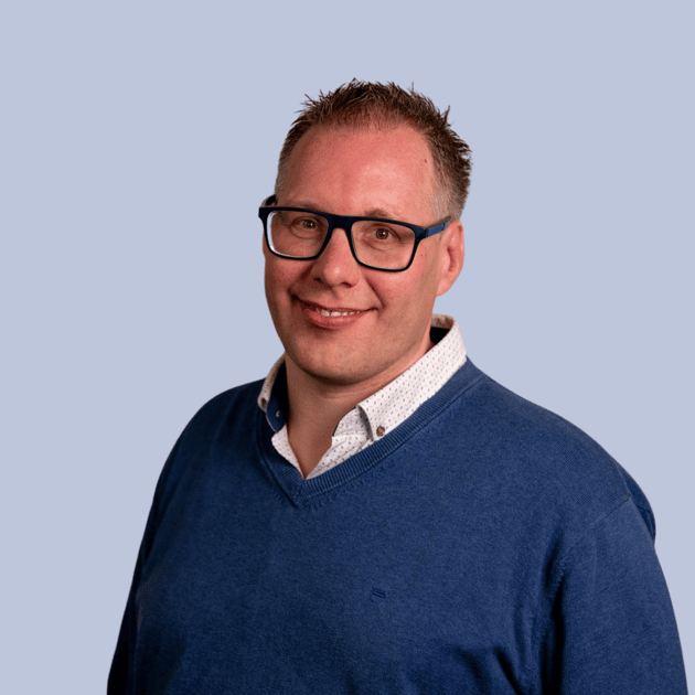 medewerker Qredits Daniel Wigger man in blauw shirt voor grijze achtergrond
