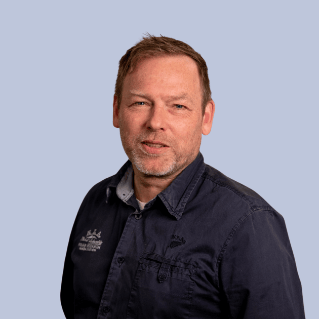 medewerker Qredits Erik de Jong man in blauw shirt voor grijze achtergrond