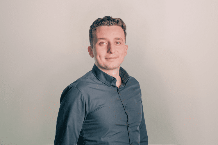 Furkan medewerker Qredits man in donker shirt voor grijze achtergrond
