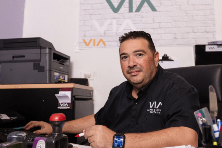 Man in zwart shirt in een kantoor achter zijn computer