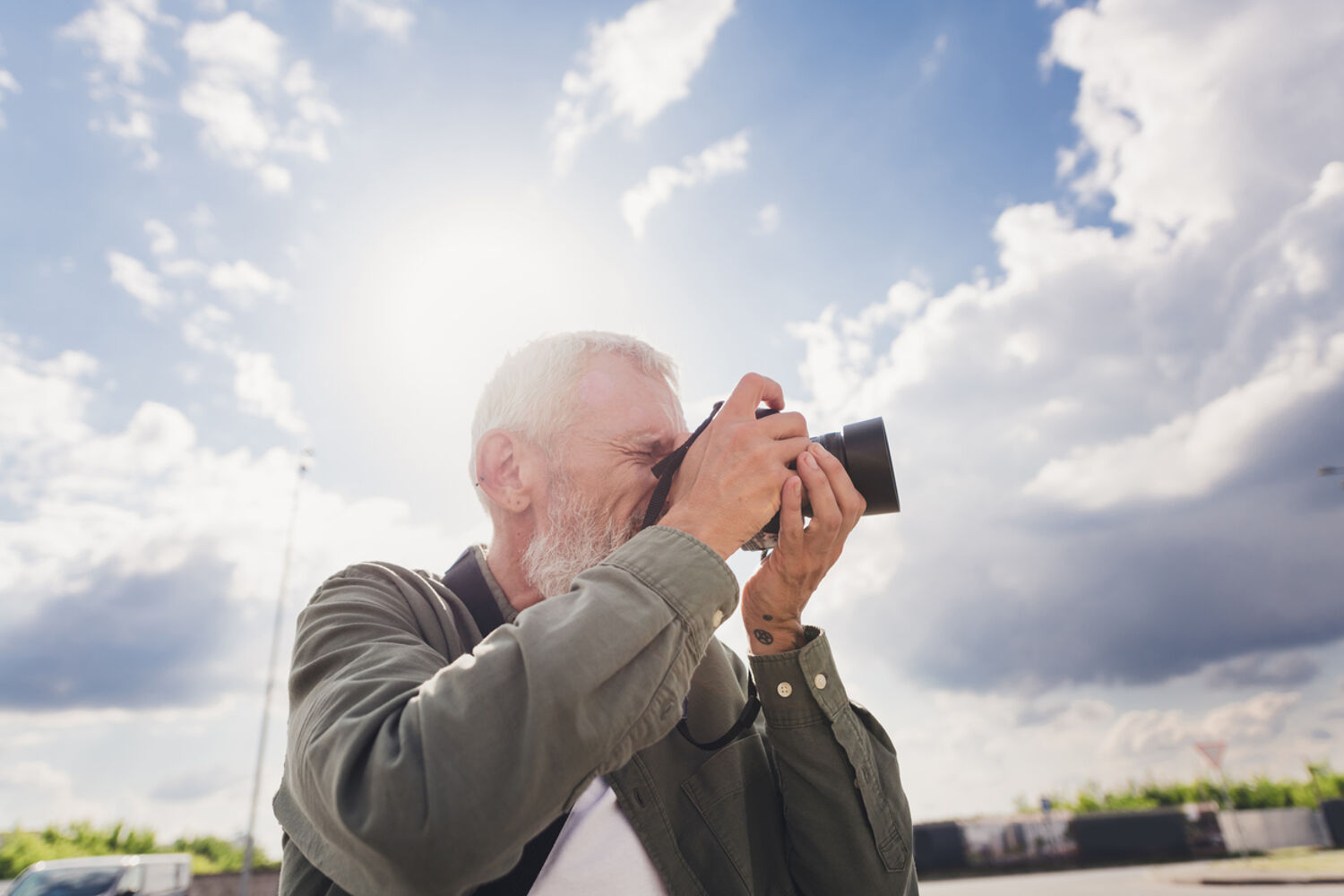 man maakt met zijn camera een foto met een blauwe lucht op de achtergrond