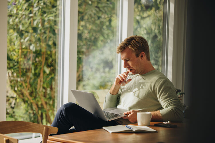 man-met-laptop-bril-in-hand