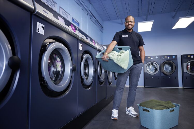 man-met-wasmand-voor-wasmachines