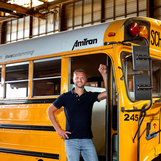 Man-staat-voor-een-gele-bus