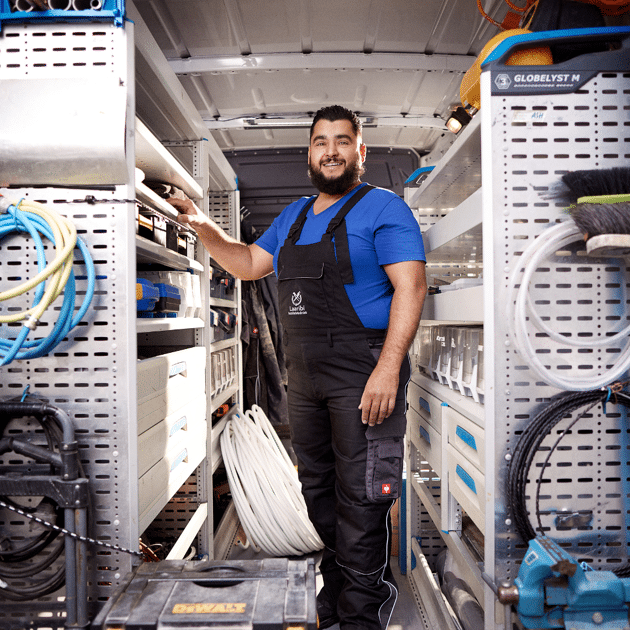 Man staat in een bus en houdt zich vast aan de zijkant