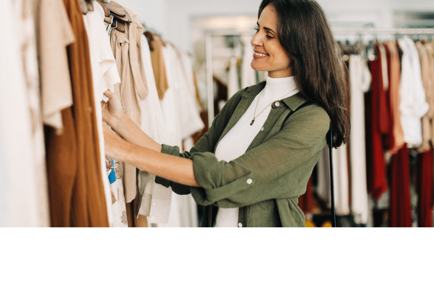 Vrouw lacht en kijkt naar kleding.