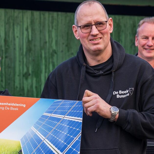 man houdt bord omhoog voor groene muur