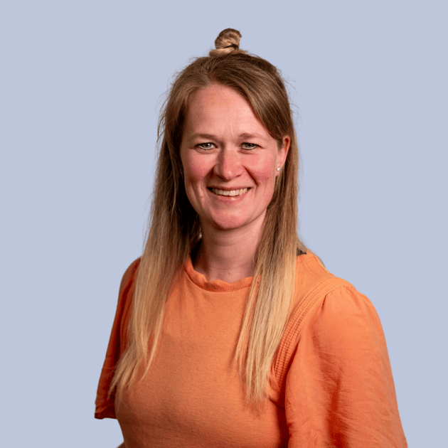 medewerker Qredits Rebekka Wassink vrouw in blauw shirt voor grijze achtergrond