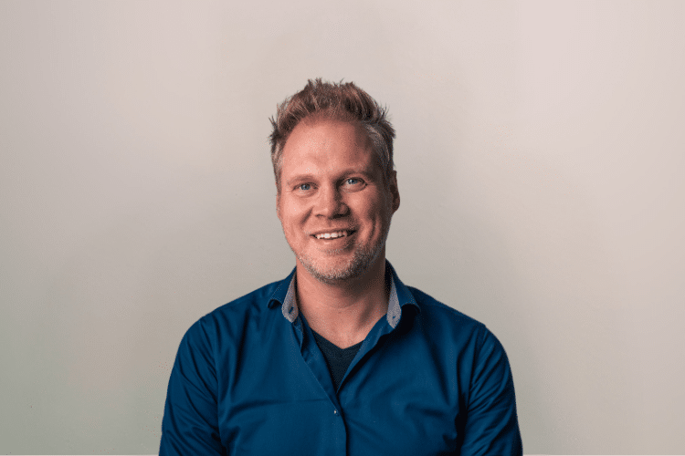 Rick medewerker Qredits man in blauw shirt voor grijze achtergrond