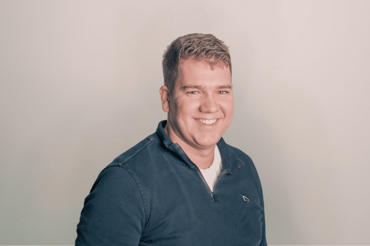 medewerker Qredits man in blauw shirt voor grijze achtergrond