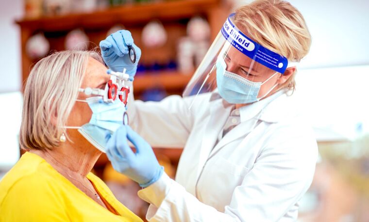 vrouw behandelt ogen van vrouw in masker