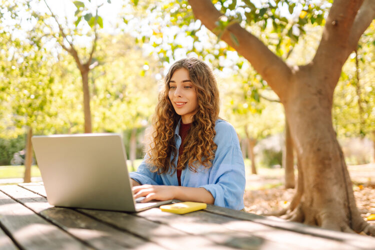 vrouw-zit-buiten-achter-laptop