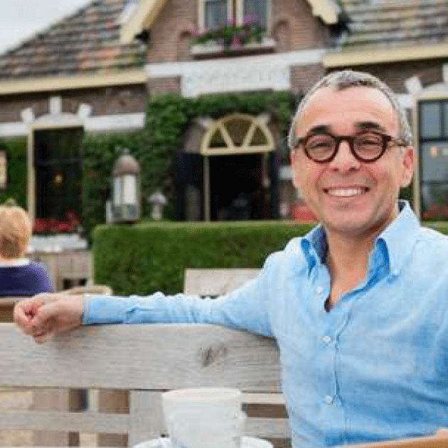 Man met bril lacht naar camera