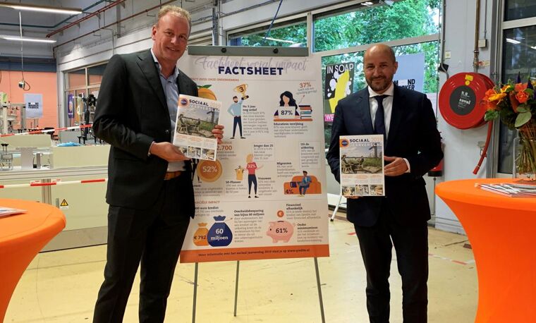Elwin en de burgermeester van Arnhem die samen een factsheet laten zien die de impact op de maatschappij weergeeft.