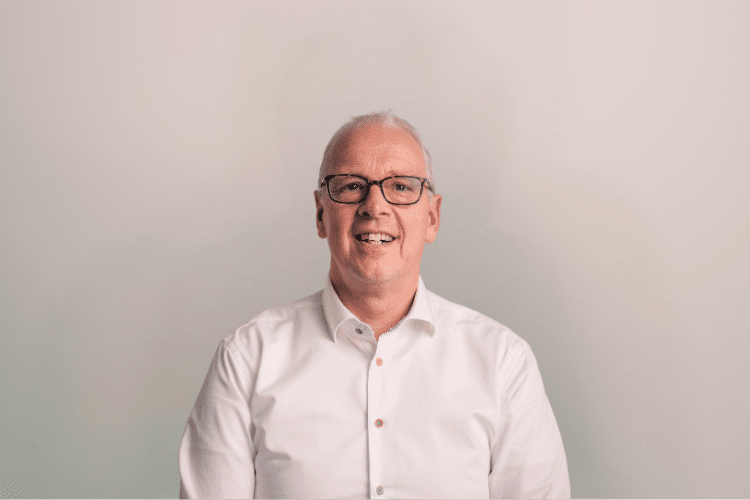 medewerker Qredits Eric Grootenhaar man in wit shirt voor grijze achtergrond