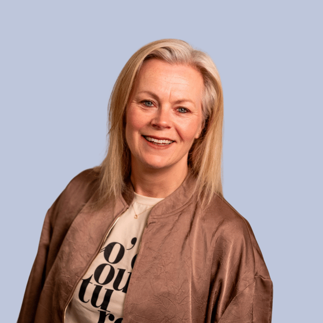 medewerker Qredits Kirsten Tuinte vrouw in beige jasje voor grijze achtergrond