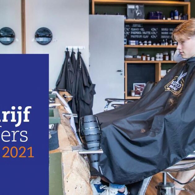 man en kind in een kapperszaak, jongen wordt geknipt.