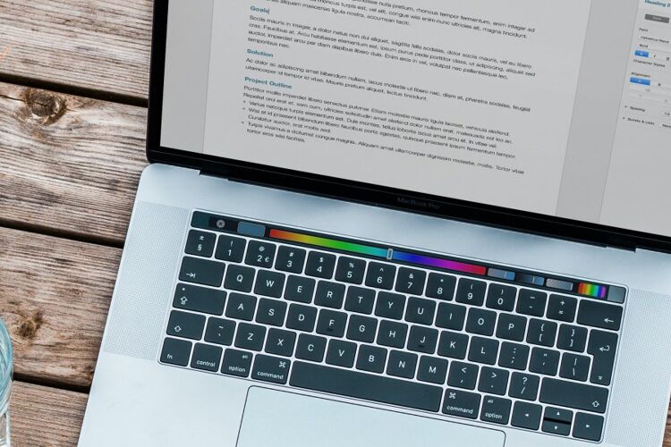 laptop-met-glas-water-kladblok-en-telefoon-op-tafel
