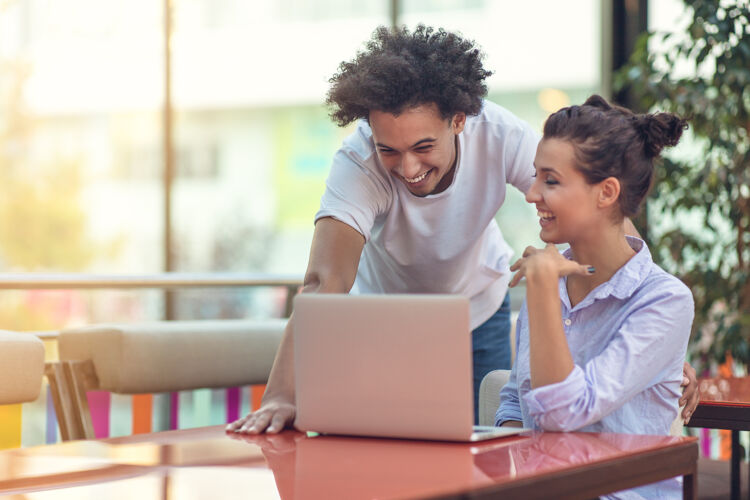 man-en-vrouw-lachen-naar-laptop
