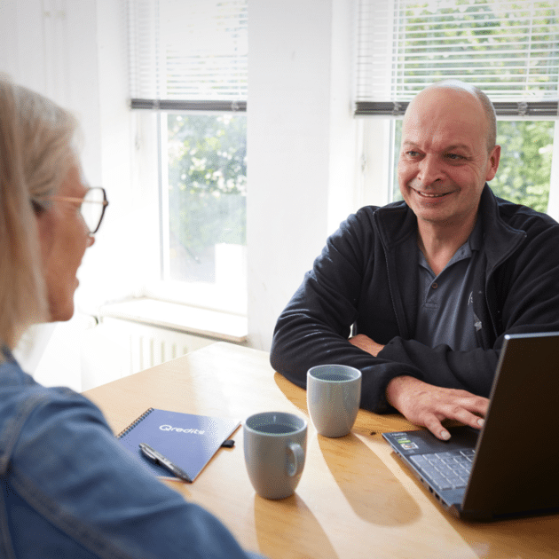 Man in zwart praat met vrouw met wat koffie