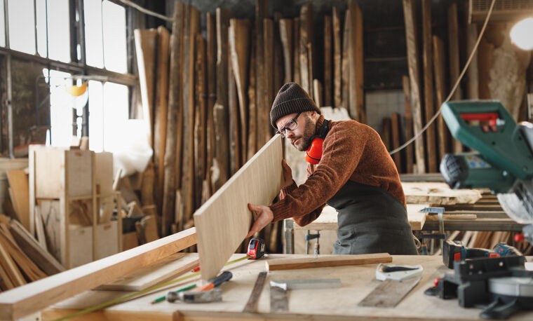 Man bekijkt een houten plaat in houtbewerking ruimte