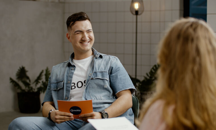 Man lacht met Qredits kaartjes in zijn hand