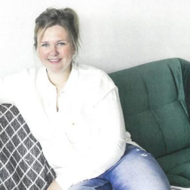 Vrouw in wit shirt zit op een bank