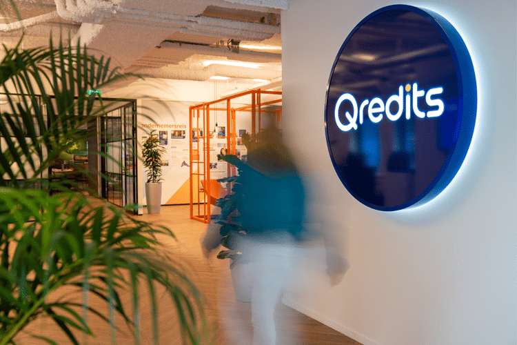 Qredits logo op witte achtergrond in receptie ruimte van kantoor