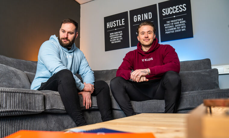 Twee mannen zitten op de bank en kijken stoer