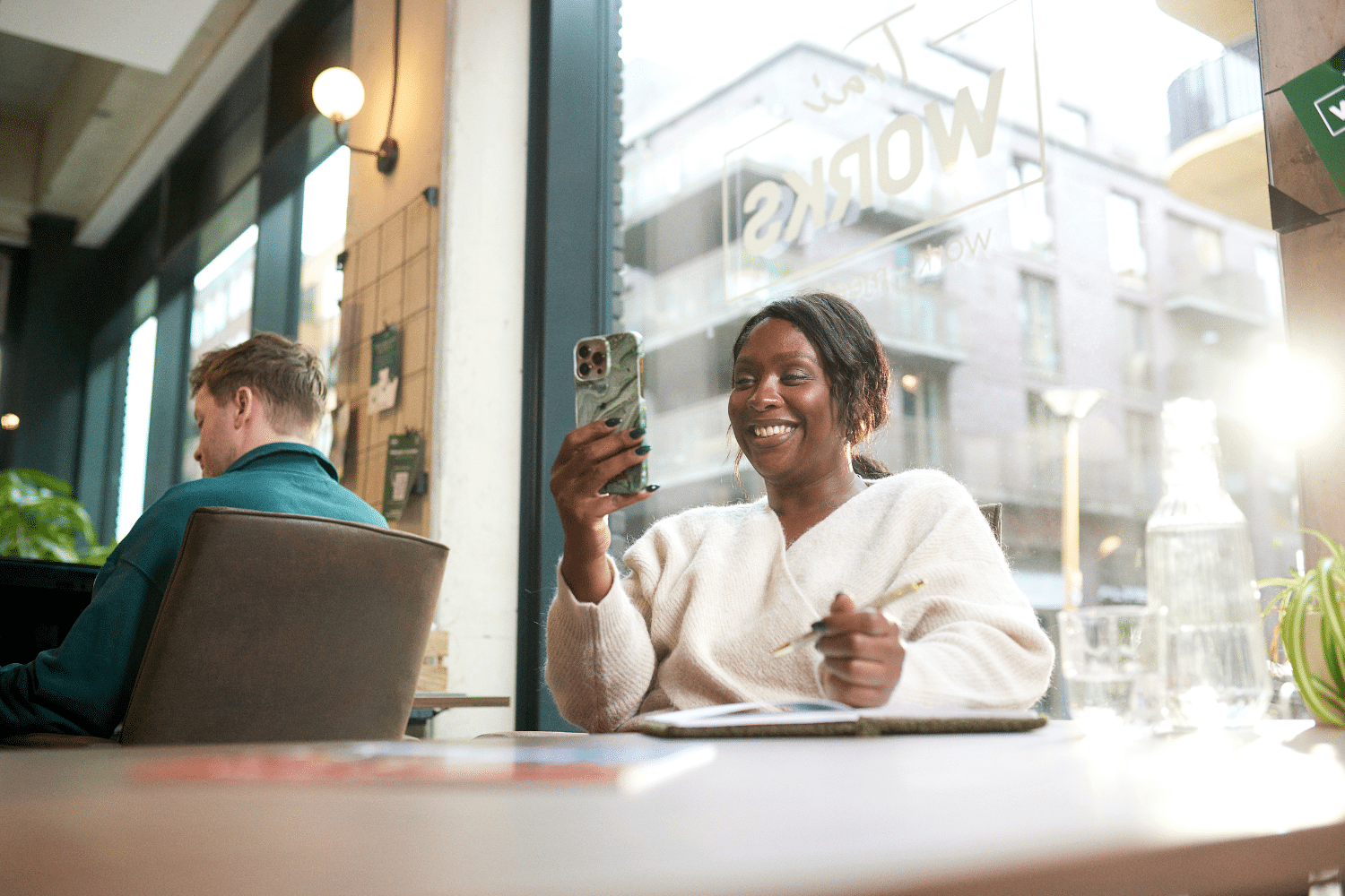vrouw-lacht-naar-telefoon Vrouw kijkt lachend naar haar telefoon
