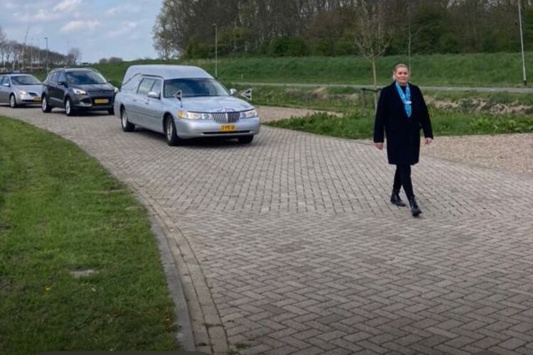 vrouw-loopt-voor-rouwauto's