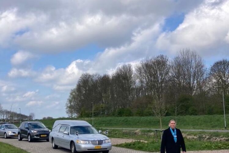 vrouw-loopt-voor-rouwauto's